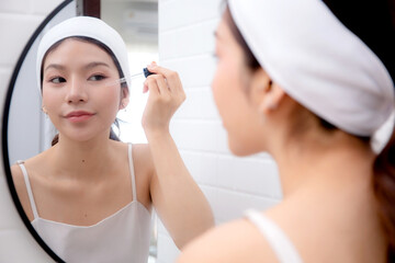 Beautiful young asian woman applying serum for rejuvenation on facial looking mirror, beauty woman applying collagen for treatment skin, self-care, skincare and makeup, cosmetic and makeup.