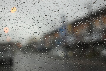rain in the city blur background, water drop on windshield of car