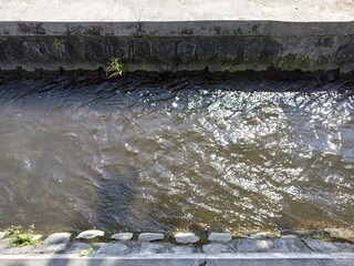 Sunlight Reflecting on Water in Concrete Irrigation Canal