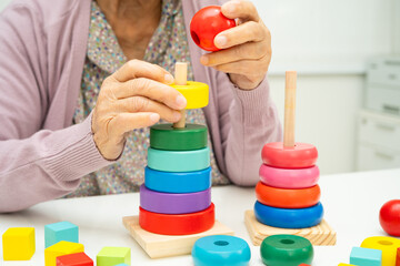 Asian elderly woman patient suffering from dementia learn practical motor skills rehabilitation.