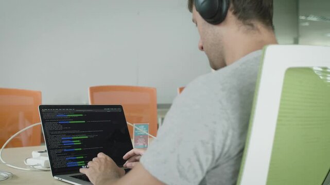 Software Developer Coding on Laptop in Office, Programmer Writing Code on Computer, Working on Programming Language in Tech Office

