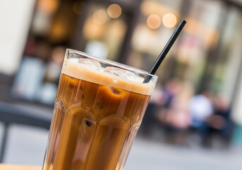 Tall Glass Of Iced Coffee With A Black Straw On A Cafe Patio, With A Blurry City Street Bokeh Background, Summer Drink, Coffee Shop, Cold Brew
