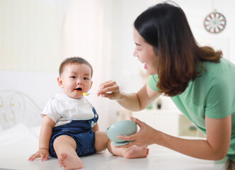 The mother who is feeding her little boy on the table wants to be happy.