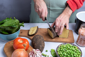 Cutting potatoes and other vegetables for cooking.
