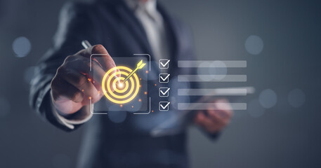 Strategic goal setting and business planning concept with a businessman pointing at a target icon...