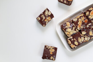 Homemade Chocolate Brownies cake with topping almond slice on plate. on white background. Top view...