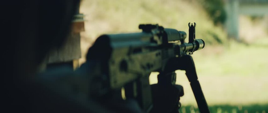 Shooter takes aim with scoped rifle during daylight training session