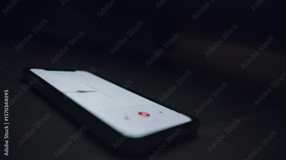 Aufkleber hand placing smartphone with recording app under bed or couch in dark room. secret voice capture app