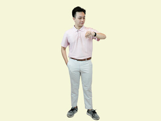 Young Asian man wearing glasses, a polo shirt, and slacks, standing with one hand in his pocket,...
