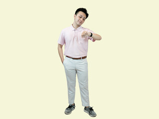 Young Asian man wearing glasses, a polo shirt, and slacks, standing with one hand in his pocket,...