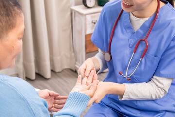 Nurse and older patient making eye contact while holding hands, expressing warmth, empathy, and...
