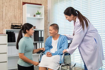 Obraz premium Senior woman in wheelchair receiving supportive visit from younger family member while doctor observes, symbolizing care, connection, and emotional bonding in medical environment, healthcare.