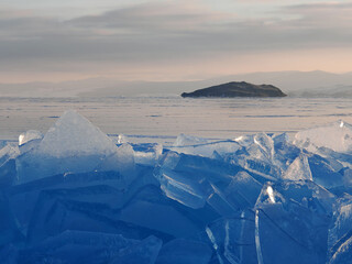 Lake Baikal in winter covered with ice and snow texture in sunset evening, Russia, Siberia