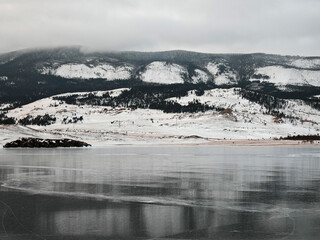 Baikal Lake in winter. Beautiful landscape with mountains reflected in ice of frozen Small Sea
