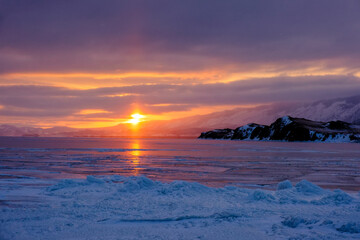 Lake Baikal in winter covered with ice and snow texture in sunset evening, Russia, Siberia