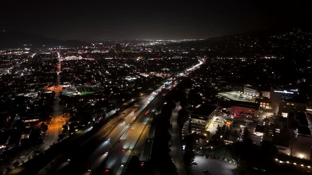 Aerial night view of city freeway and illuminated urban landscape in Los Angeles