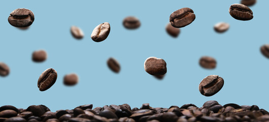 roasted coffee beans falling and floating in the air with a blue background
