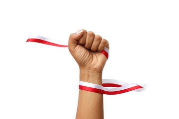 The hands of a man holding a red and white ribbon as a symbol of the Indonesian flag