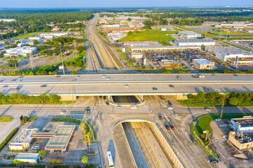 Drone perspective capturing intricate highway system with multiple levels intersecting roads in suburban area of Houston, Texas wide lanes, overpasses, urban development.