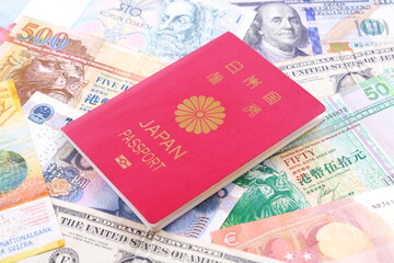 日本のパスポート（一般旅券10年用赤色）と外国のお金で、海外旅行のイメージ

