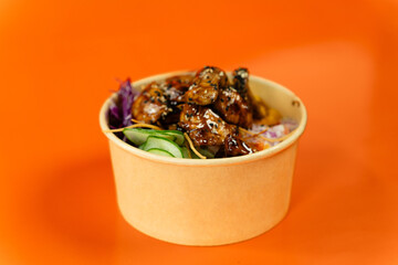 Vegetable and protein poke bowl on orange background. Complete and detail of the dish.