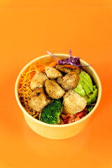 Vegetable and protein poke bowl on orange background. Complete and detail of the dish.