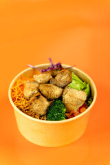 Vegetable and protein poke bowl on orange background. Complete and detail of the dish.