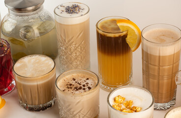 A collection of cozy autumn beverages with spices, popcorn, and fruit, showcasing coffee and tea varieties