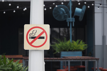 No smoking sign in outdoor cafe area during daytime