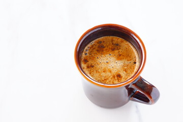 淹れたてのコーヒー（カフェラテ）が入ったマグカップを、真上から俯瞰した画像
