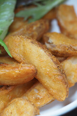 Crispy golden potato wedges served with fresh greens