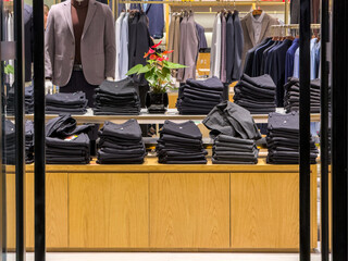 Contemporary Men's Fashion Showcase Featuring Neatly Stacked Apparel and Elegant Decor