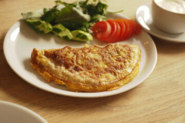 Delicious omelette with fresh salad and tomatoes at cafe