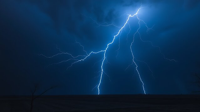 A dramatic lightning strike illuminates the dark stormy sky with electric blue brilliance.