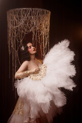 Young Caucasian circus performer or burlesque dancer in golden vintage corset, front view, posing...