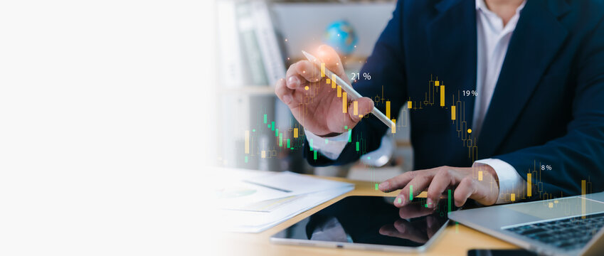 Businessman in suit analyzing financial stock market data with digital tablet, candlestick chart, and futuristic technology interface. Modern investment and financial analysis concept.