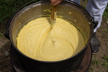 the process of making polenta, a traditional Romanian dish.Mămăliga is a dish similar to polenta,...
