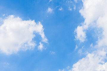 Blue sky filled with white fluffy clouds on a bright sunny day. Nature background.