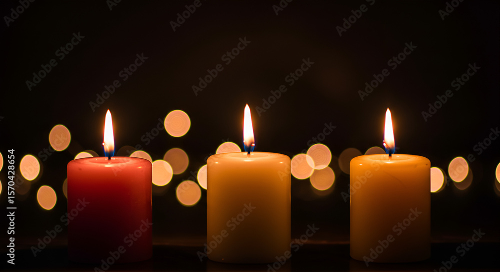 Poster Three candles glowing against a dark background with bokeh lights creating warmth