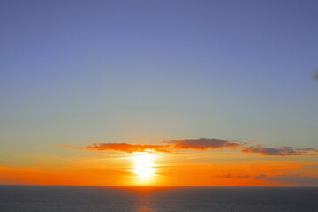 Fototapeta premium Golden Atlantic Sunset Over Calm Ocean Waters – Tranquil Evening Sky with Vibrant Orange and Blue Hues at Cliff Of Moher, County Clare, Ireland – Peaceful Coastal Nature Landscape