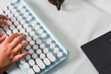 Child's hands typing on a modern retro-style keyboard. Creative tech scene with vintage elements and a clean, minimalist workspace