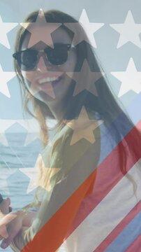 American flag design pattern against portrait of caucasian woman holding a fishing road on a boat