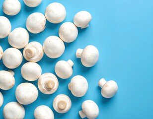 Fresh white button mushrooms scattered on a bright blue background, showcasing their smooth caps and short stems.