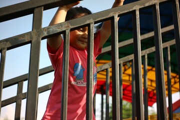 girls are playing in the playground area near the iron fence