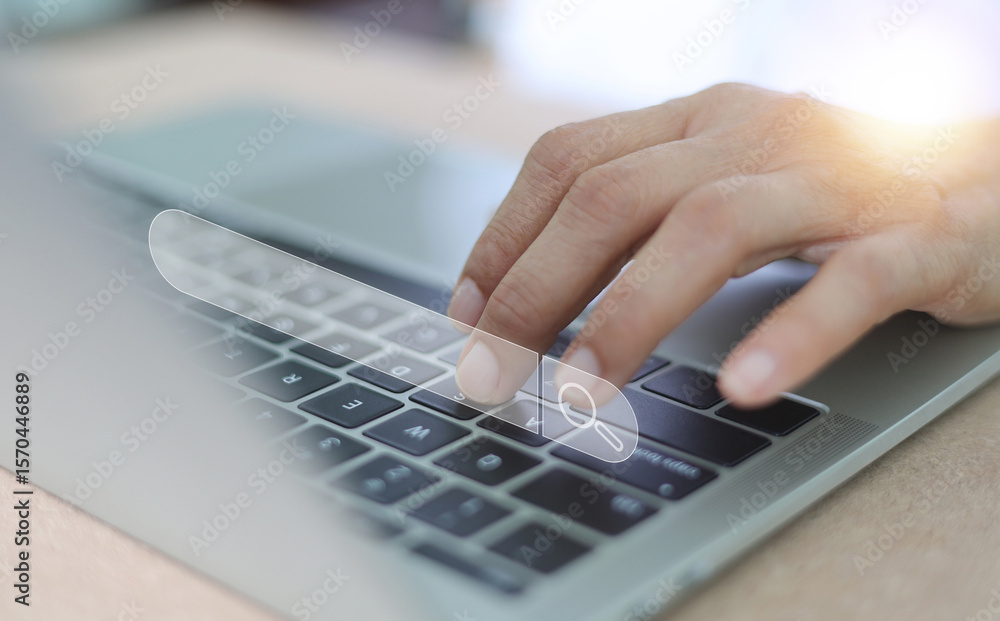 Poster a close-up shot of a person's hand typing on a laptop keyboard, with a prominent, superimposed searc