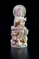 Antique, Avalokiteshvara Bodhisattva (Guanyin) Mammoth ivory fossil carving isolated on black background