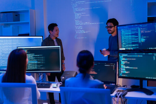Asian software engineer or programmer team working late in development office,problem solving or algorithm of ai assistant helping for work.software developer,digital technology security concept