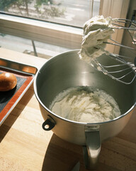 Fresh whipped cream ready in mixing bowl.