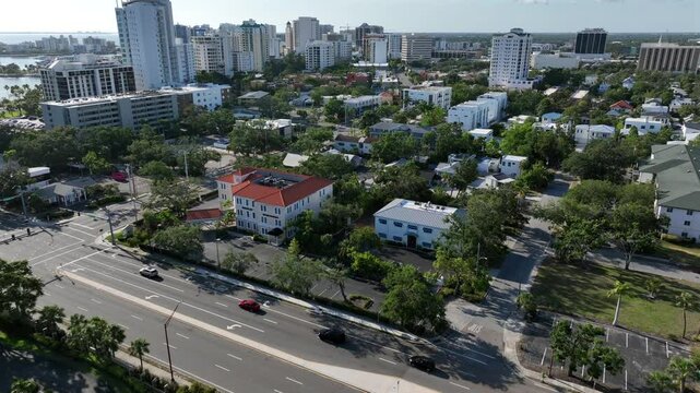 Aerial approaching fight over Main Street of sarasota city in sunlight. Towers and housing area with single family hokes in American town. Landing sho