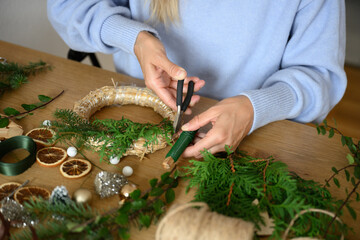 Florist creating christmas wreath with natural materials